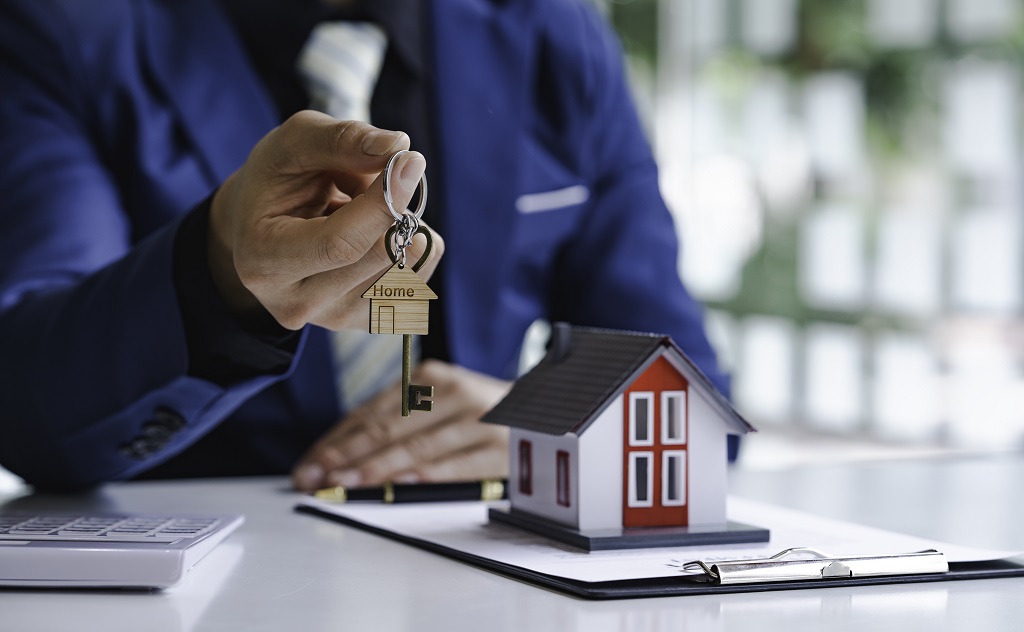 real-estate-agent-passing-house-model-to-his-clien-2023-11-27-05-24-00-utc